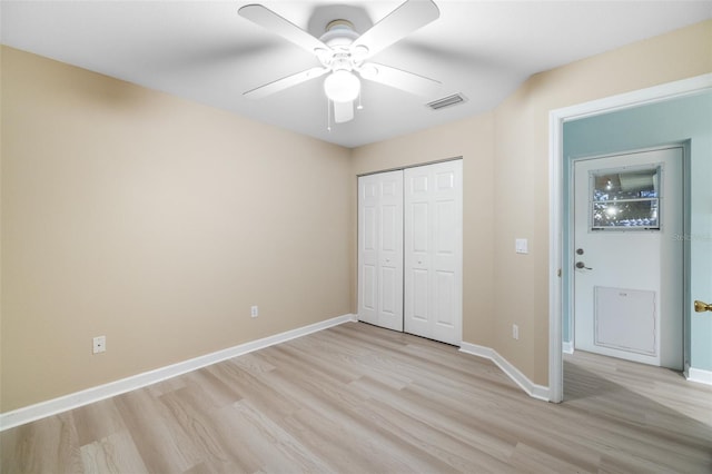 unfurnished bedroom featuring ceiling fan, a closet, and light wood-type flooring