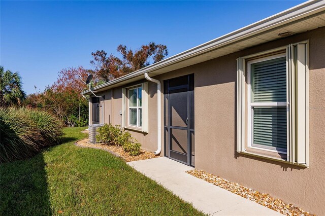 view of exterior entry with a lawn