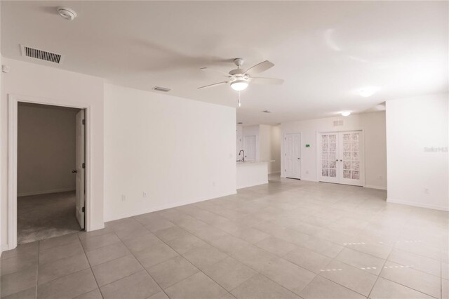 unfurnished room with sink, french doors, light tile patterned floors, and ceiling fan