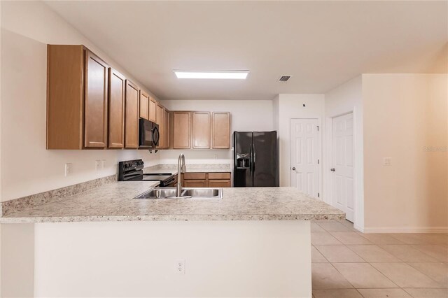 kitchen with light tile patterned floors, black appliances, sink, and kitchen peninsula