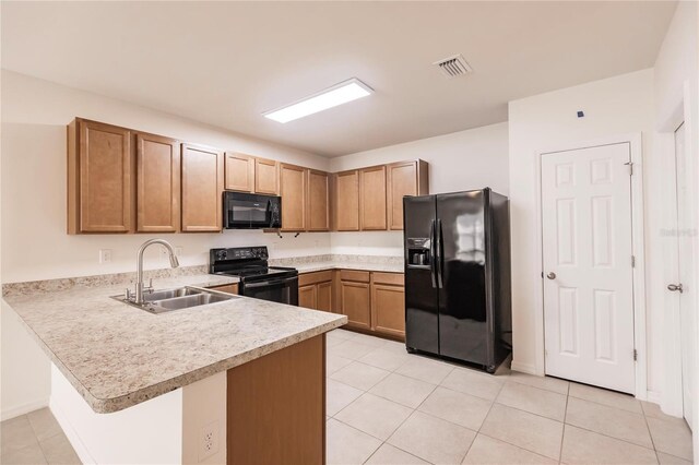 kitchen with light tile patterned floors, black appliances, sink, and kitchen peninsula