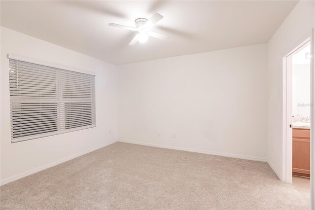 spare room with ceiling fan and light colored carpet