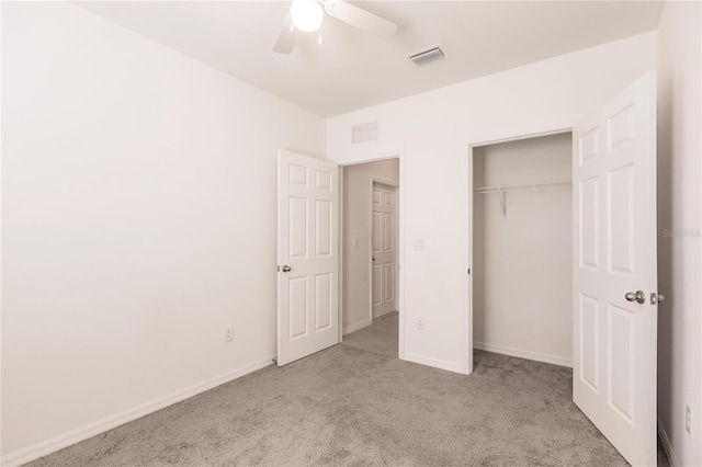 unfurnished bedroom featuring light colored carpet, a closet, and ceiling fan