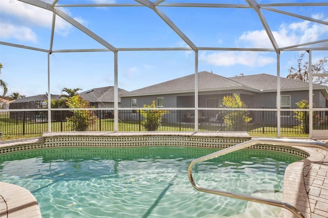 view of swimming pool featuring glass enclosure