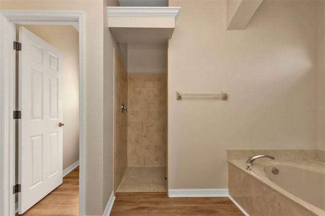 bathroom featuring hardwood / wood-style flooring and plus walk in shower