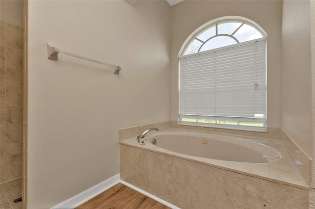 2262 Rio De Janeiro Ave, Punta Gorda, FL 33983 - bathroom with a garden tub, wood finished floors, and tiled shower