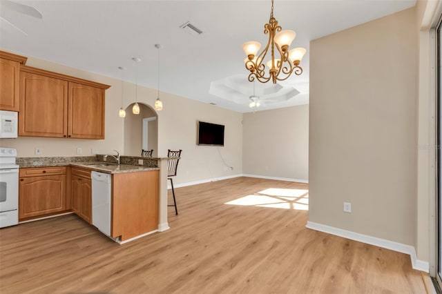 2262 Rio De Janeiro Ave, Punta Gorda, FL 33983 - kitchen featuring white appliances, a ceiling fan, light wood-type flooring, a peninsula, and decorative light fixtures