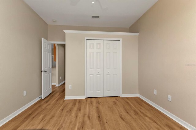 unfurnished bedroom with ceiling fan, light hardwood / wood-style floors, and a closet