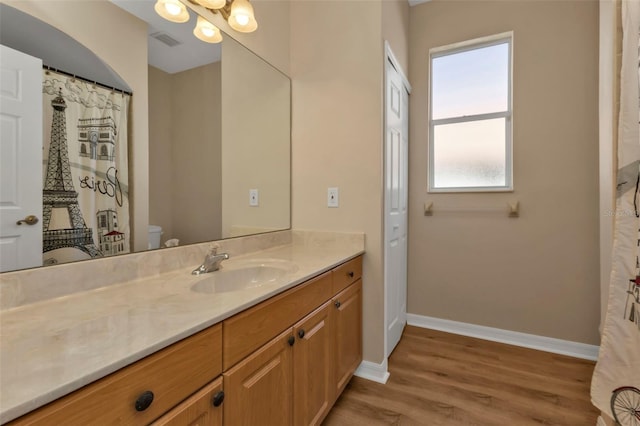 bathroom with hardwood / wood-style floors, vanity, and toilet