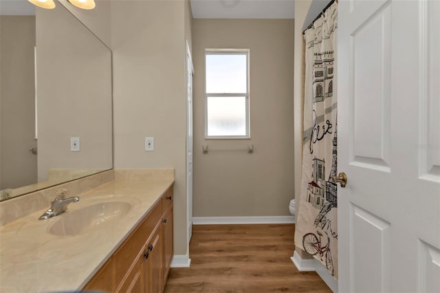 bathroom with wood-type flooring, vanity, and toilet