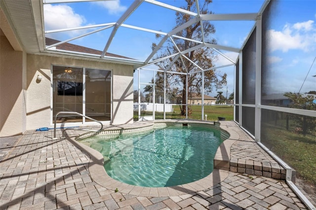 view of pool with glass enclosure and a patio