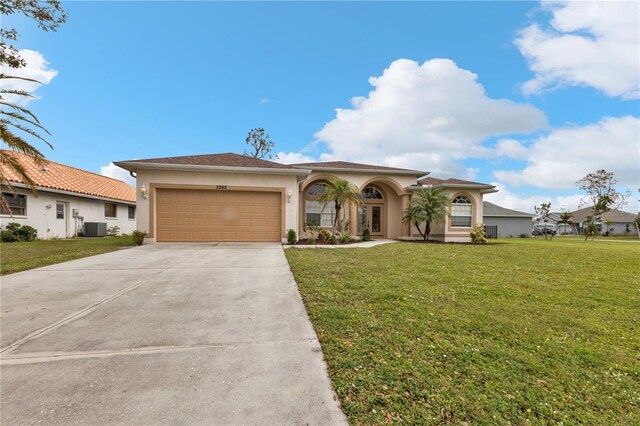 2262 Rio De Janeiro Ave, Punta Gorda, FL 33983 - mediterranean / spanish home featuring stucco siding, an attached garage, cooling unit, concrete driveway, and a front yard