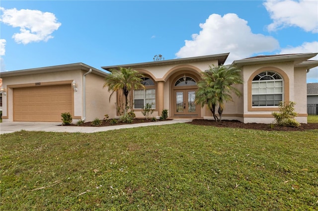 view of front facade with french doors, a front yard, and a garage