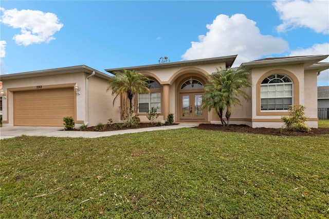 2262 Rio De Janeiro Ave, Punta Gorda, FL 33983 - view of front of home featuring french doors, stucco siding, a garage, and driveway