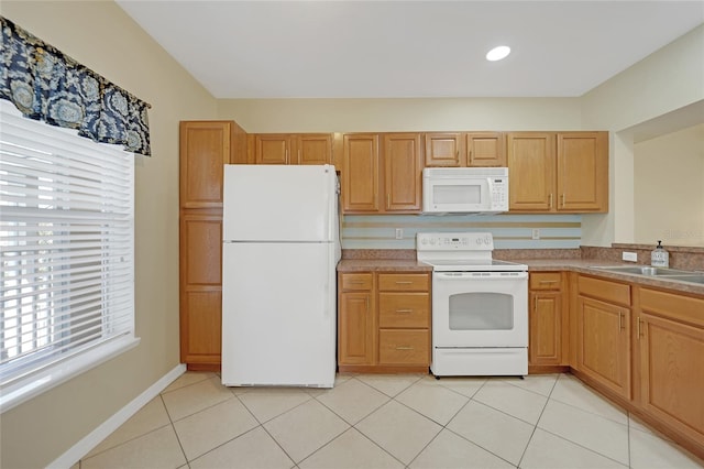 kitchen featuring light tile patterned flooring, sink, and white appliances