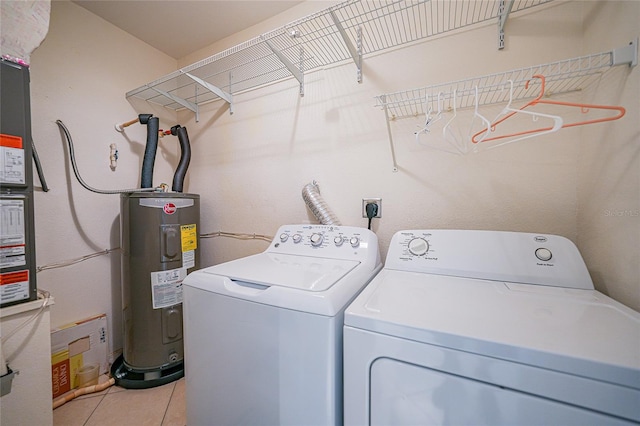 washroom with washer and clothes dryer, electric water heater, and light tile patterned flooring