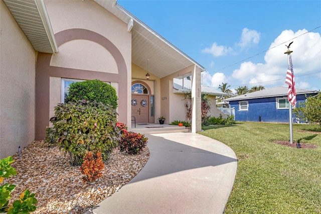 doorway to property with a lawn