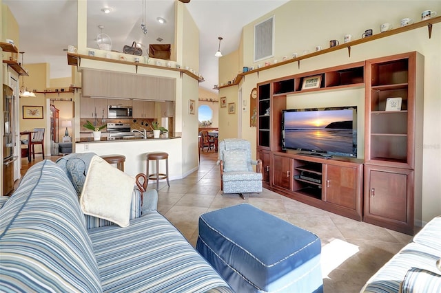 living room featuring high vaulted ceiling and light tile patterned floors