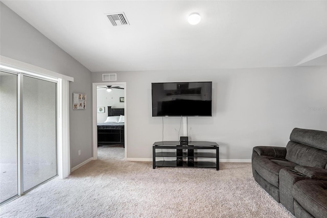 living room featuring vaulted ceiling, light carpet, and ceiling fan