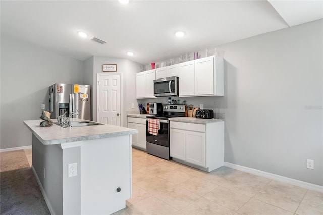 kitchen featuring sink, white cabinetry, stainless steel appliances, light tile patterned floors, and a kitchen island with sink