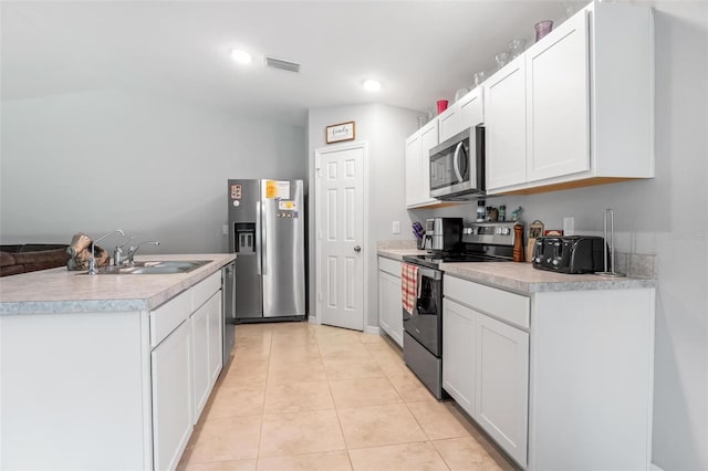 kitchen featuring white cabinetry, stainless steel appliances, sink, and light tile patterned floors