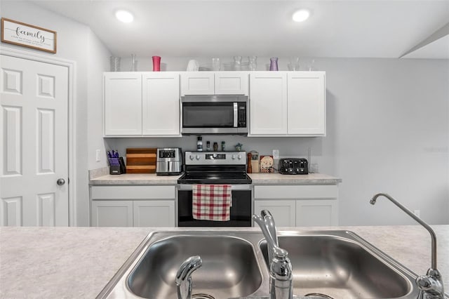 kitchen featuring sink, appliances with stainless steel finishes, and white cabinetry