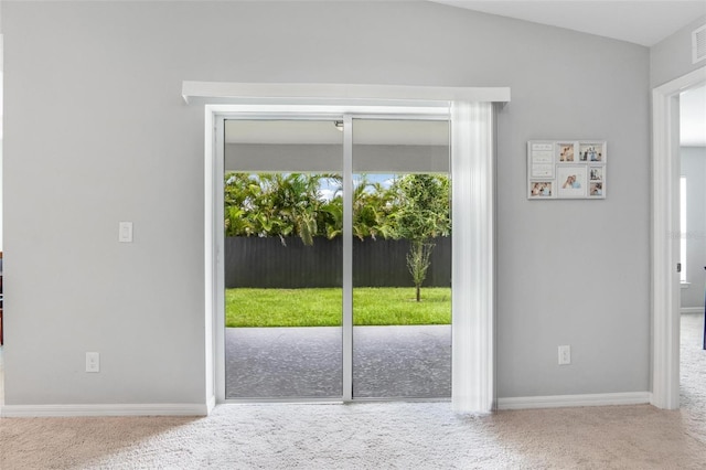 doorway featuring carpet flooring and vaulted ceiling