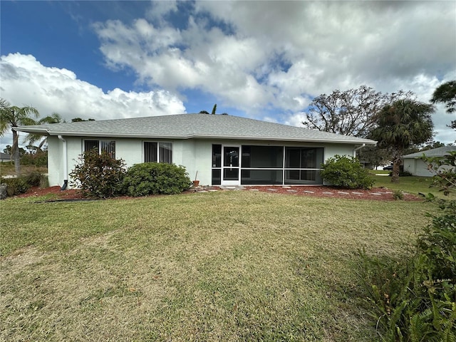 back of property featuring a lawn and a sunroom