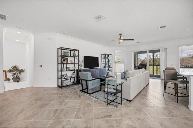 tiled living room with ceiling fan and ornamental molding