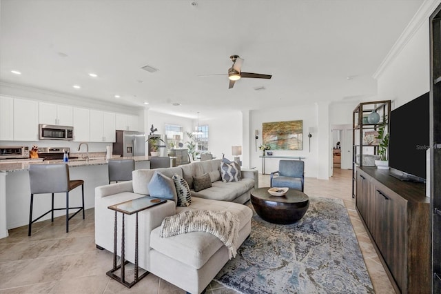 living room with light tile patterned floors, sink, crown molding, and ceiling fan