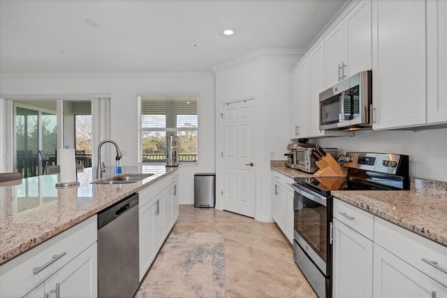 kitchen with white cabinets, sink, crown molding, and stainless steel appliances