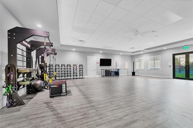 exercise area with light wood-type flooring, french doors, and ceiling fan