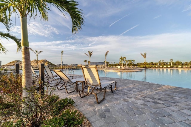 view of pool with a water view and a patio area