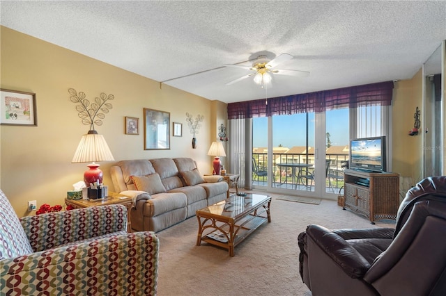 living room with a textured ceiling, light colored carpet, and ceiling fan