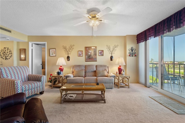 carpeted living room with a textured ceiling and ceiling fan