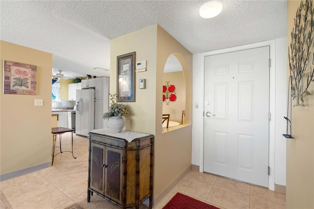 tiled entryway featuring ceiling fan and a textured ceiling