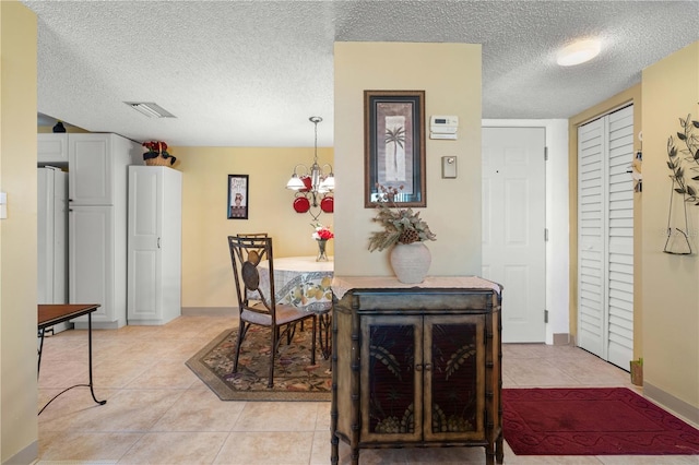 25188 Marion Ave Unit B304, Punta Gorda, FL 33950 - dining area with a textured ceiling, light tile patterned floors, baseboards, an inviting chandelier, and visible vents