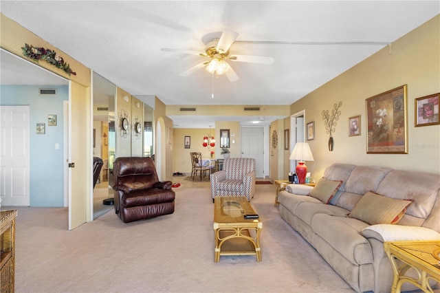 carpeted living room with ceiling fan