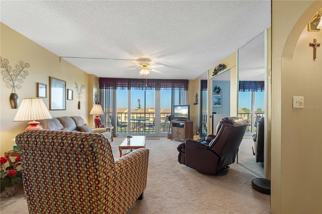 living room with carpet floors, a textured ceiling, and ceiling fan