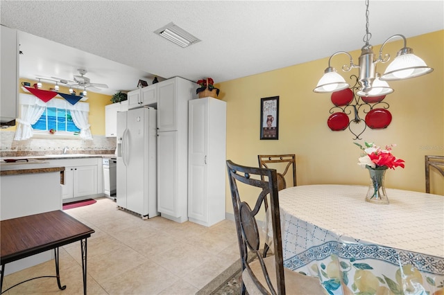 25188 Marion Ave Unit B304, Punta Gorda, FL 33950 - dining space featuring light tile patterned floors, visible vents, ceiling fan with notable chandelier, and a textured ceiling