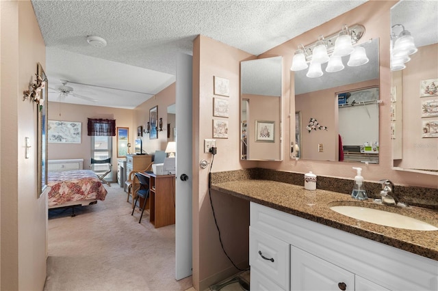 bathroom featuring vanity, a textured ceiling, and ceiling fan