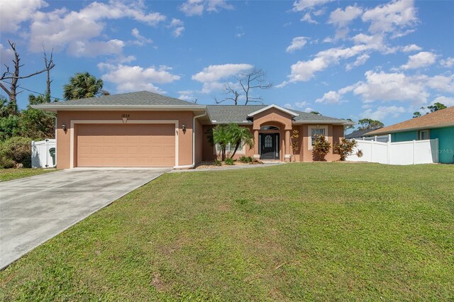 single story home with a front yard, an attached garage, stucco siding, and driveway