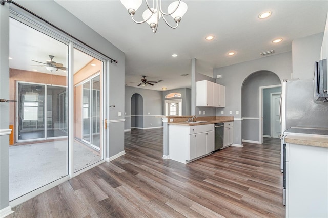 kitchen featuring kitchen peninsula, white cabinets, stainless steel dishwasher, wood-type flooring, and sink