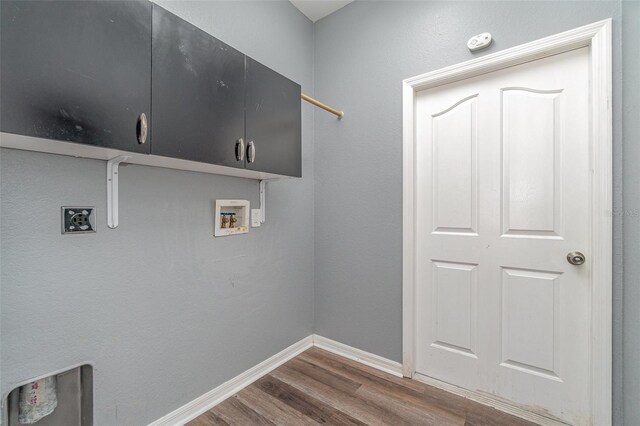laundry room featuring cabinet space, dark wood-type flooring, electric dryer hookup, washer hookup, and baseboards