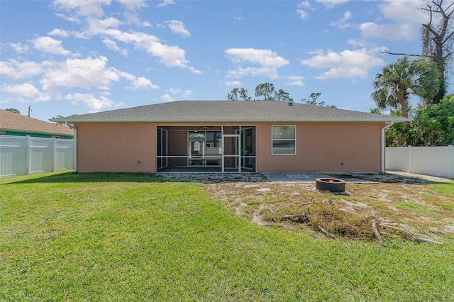 rear view of property featuring a patio, a yard, and a sunroom