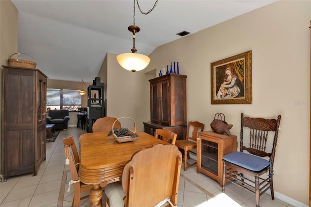 dining area with vaulted ceiling and light tile patterned floors