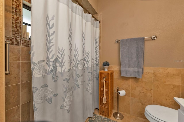 bathroom with vanity, toilet, walk in shower, and tile walls