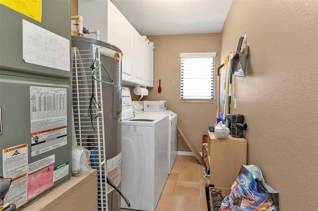 clothes washing area with independent washer and dryer, heating unit, light tile patterned floors, and cabinets