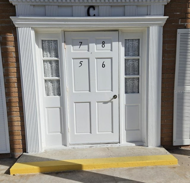 property entrance featuring brick siding