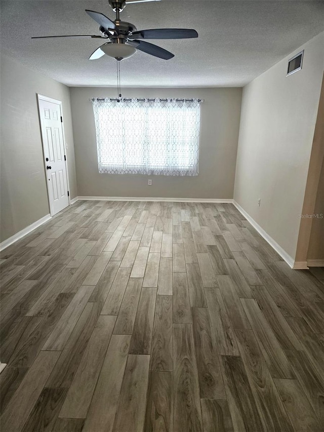 unfurnished room with hardwood / wood-style flooring, a textured ceiling, ceiling fan, and a healthy amount of sunlight